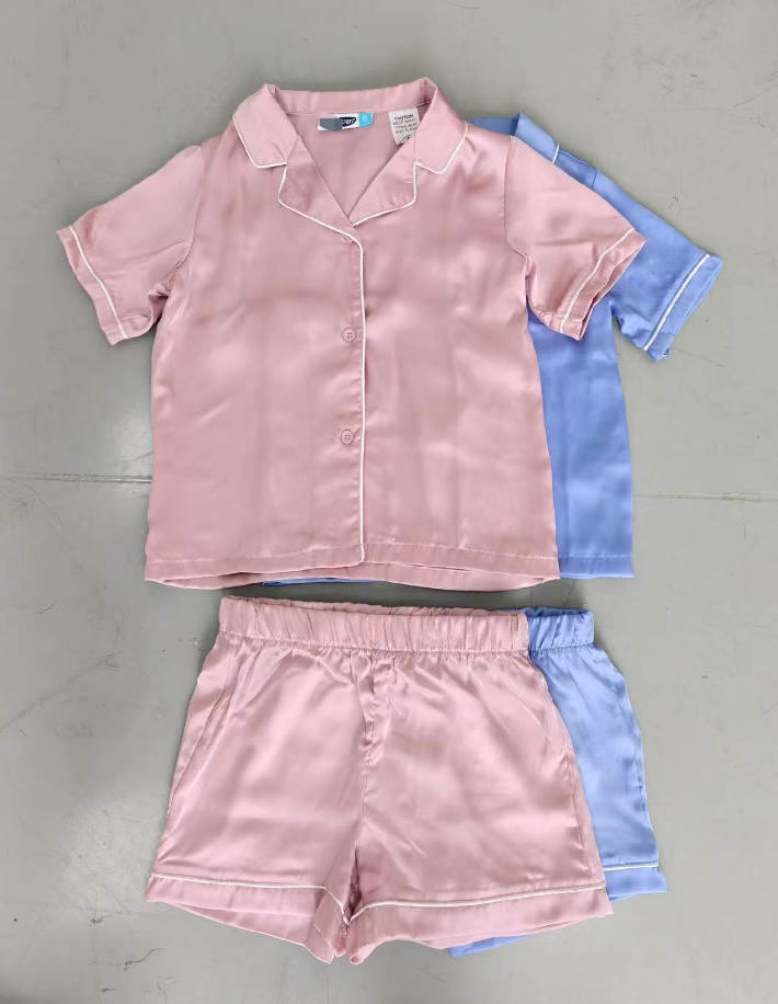 Close-up of premium contrast piping line work and glossy smooth satin fabric texture on children sleepwear