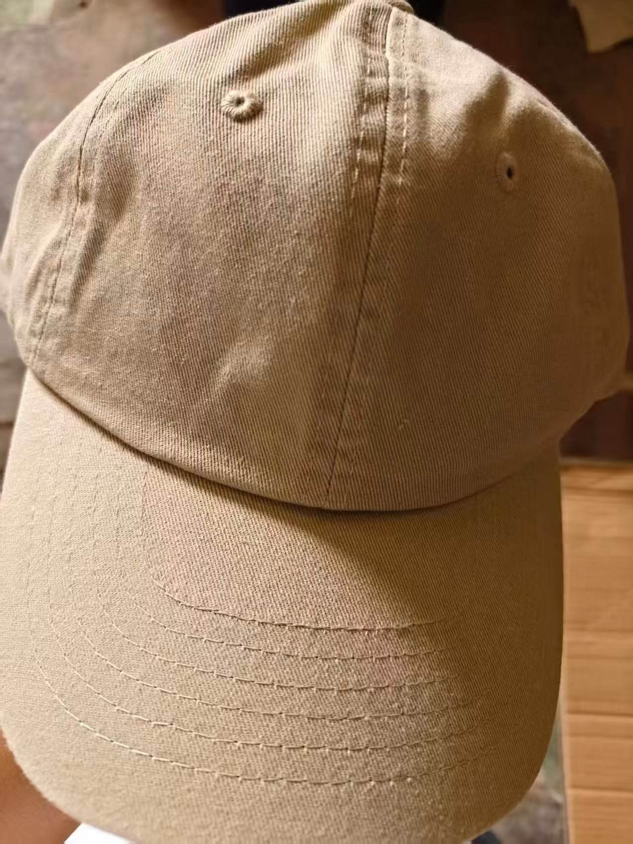 Detailed shot of the precision multi-row stitching on the curved brim and breathable embroidered eyelets of the dad hat